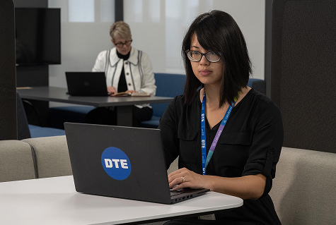 A woman taking notes while working on her computer