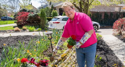 Woman preparing to plant a flower in a garden.