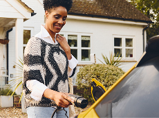 Woman charging her EV in front of her home